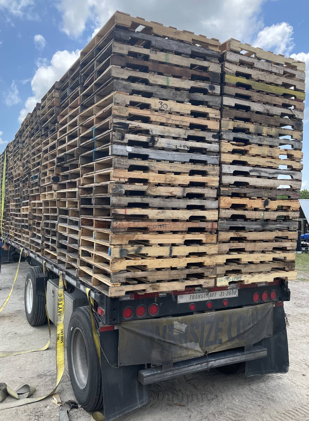 Flatbed truck loaded with ISPM-15 certified pallets for Florida port export delivery