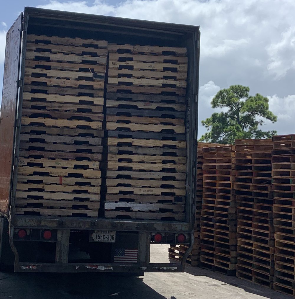 Delivery truck loaded with pallets at Florida pallet supplier yard